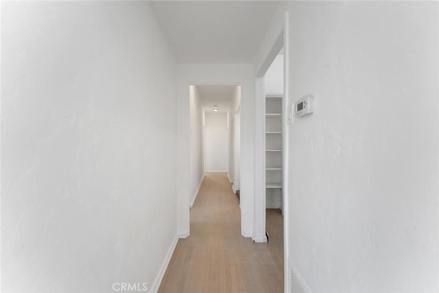 hallway with light hardwood / wood-style floors