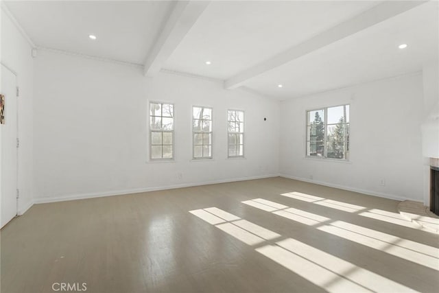 spare room featuring lofted ceiling with beams and hardwood / wood-style floors