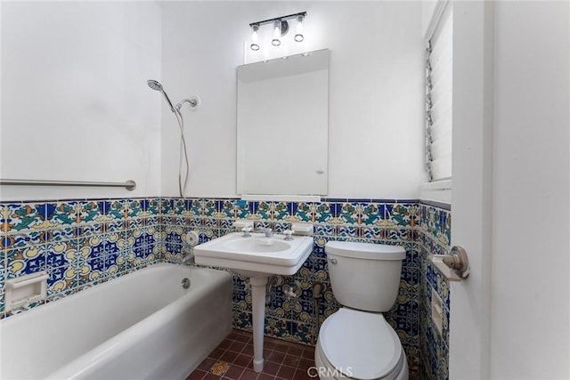 bathroom with sink, tile patterned flooring, tile walls, toilet, and a bathing tub