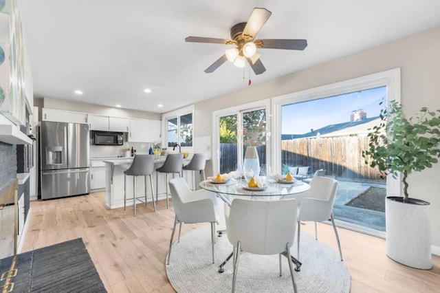 dining area with ceiling fan and light hardwood / wood-style floors