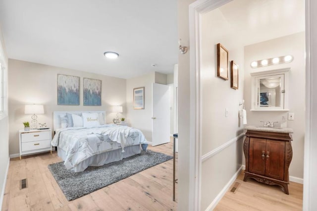 bedroom with sink and light hardwood / wood-style floors