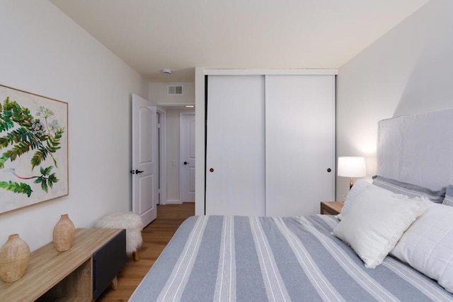 bedroom with light hardwood / wood-style floors and a closet