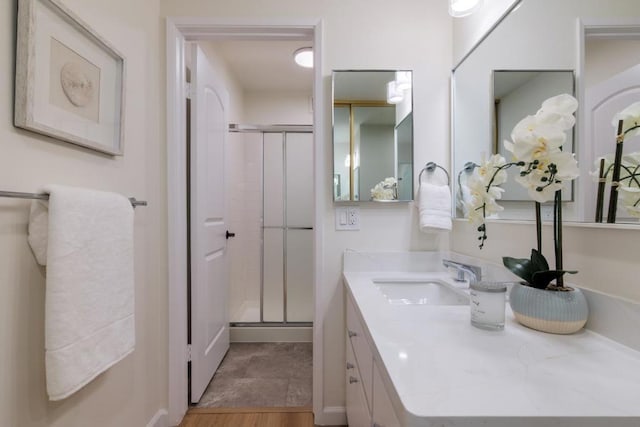 bathroom featuring walk in shower and vanity