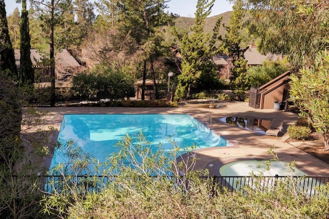 view of swimming pool with a mountain view and a patio