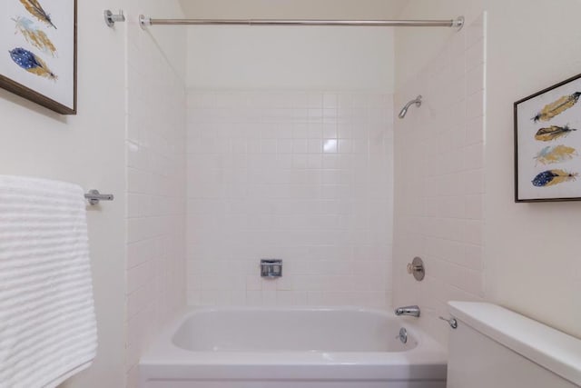 bathroom featuring tiled shower / bath and toilet