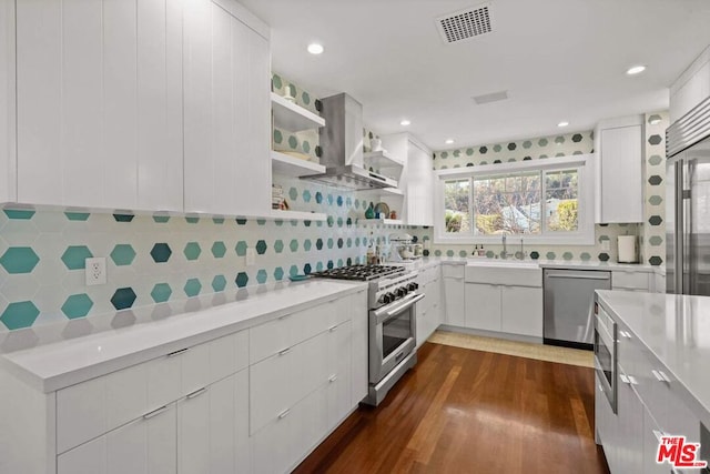 kitchen with sink, island range hood, stainless steel appliances, and white cabinets