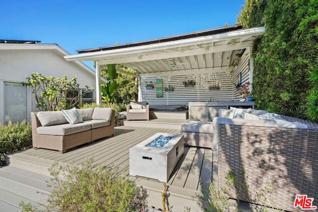 wooden terrace with an outdoor living space with a fire pit