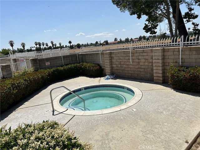 view of pool with a hot tub