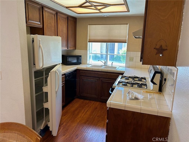 kitchen with tile countertops, dark hardwood / wood-style flooring, sink, and black appliances