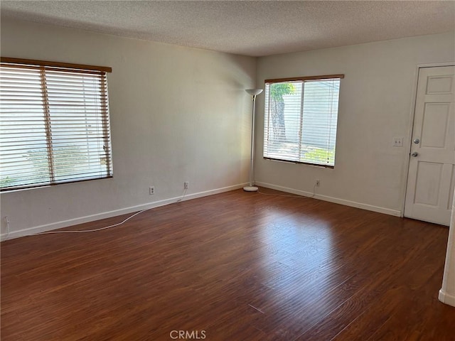 unfurnished room with dark hardwood / wood-style floors and a textured ceiling