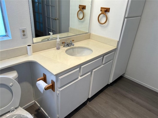 bathroom with vanity, hardwood / wood-style flooring, and toilet