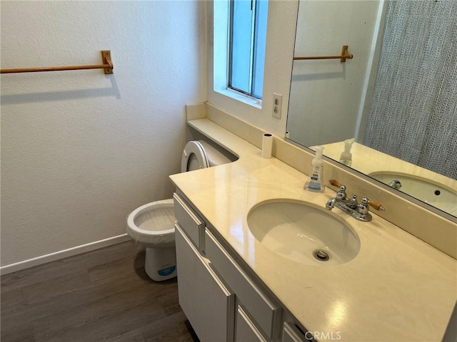 bathroom with hardwood / wood-style flooring, vanity, and toilet