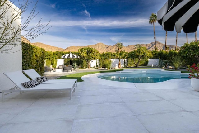 view of swimming pool with a mountain view and a patio area