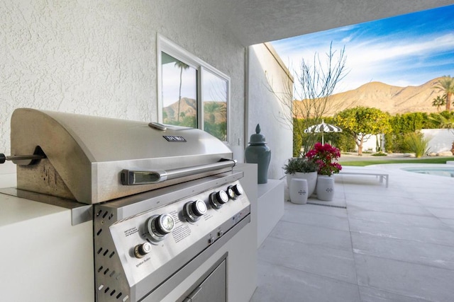 view of patio / terrace featuring a mountain view, area for grilling, and an outdoor kitchen