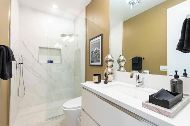 bathroom featuring tiled shower, vanity, and toilet