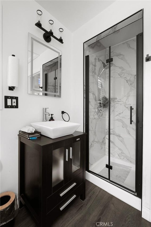 bathroom featuring a shower with door, wood-type flooring, and vanity