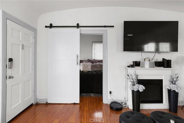 living room with wood-type flooring and a barn door