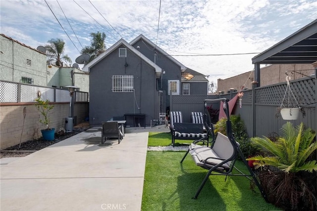 back of property with a lawn and a patio area