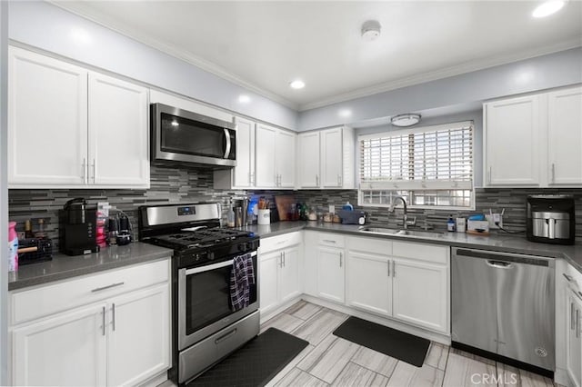 kitchen with white cabinetry, appliances with stainless steel finishes, sink, and decorative backsplash