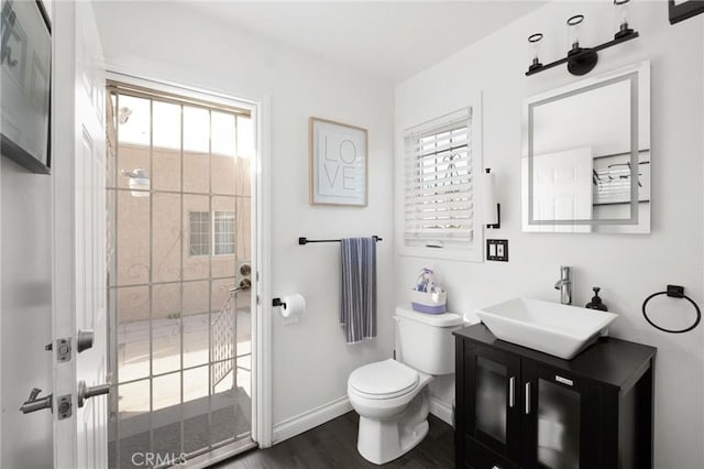 bathroom featuring vanity, hardwood / wood-style flooring, a wealth of natural light, and toilet