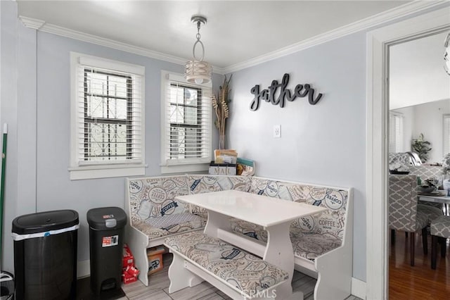 dining area featuring breakfast area, hardwood / wood-style floors, and ornamental molding