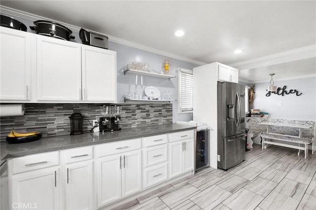 kitchen featuring backsplash, stainless steel appliances, crown molding, and white cabinets