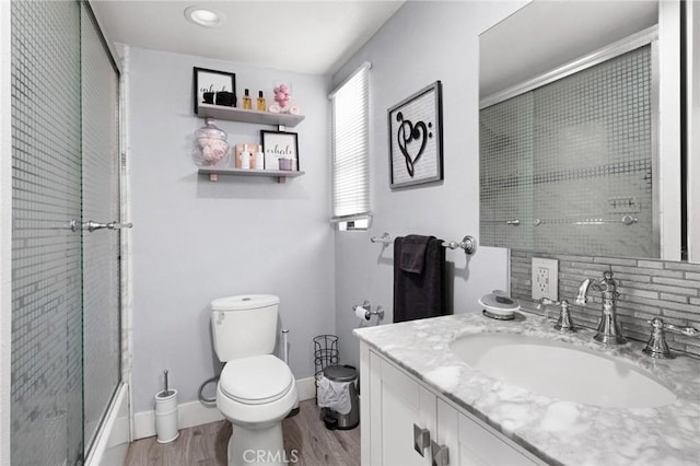 bathroom with wood-type flooring, vanity, and toilet