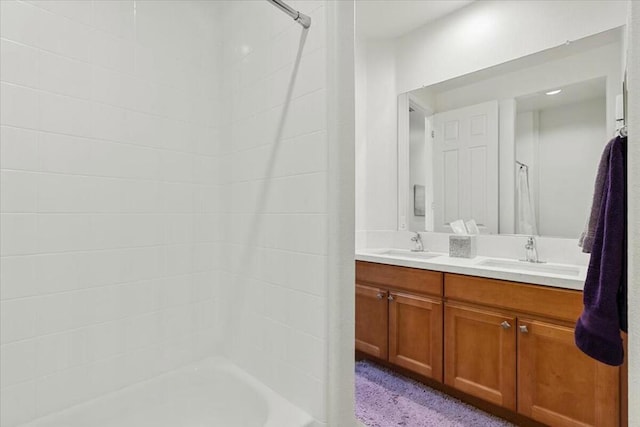 bathroom featuring tiled shower and vanity