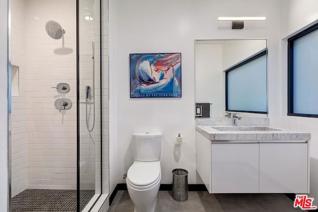 bathroom with vanity, toilet, and a shower with shower door