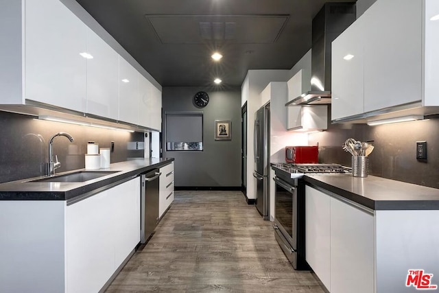 kitchen with white cabinetry, appliances with stainless steel finishes, sink, and wall chimney exhaust hood