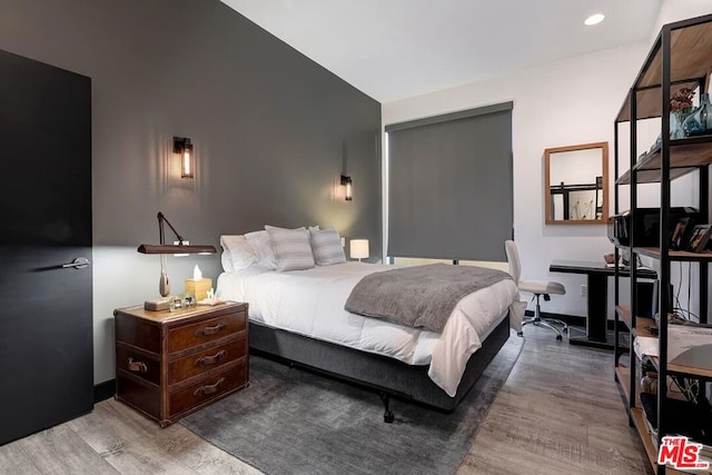 bedroom featuring hardwood / wood-style floors and vaulted ceiling