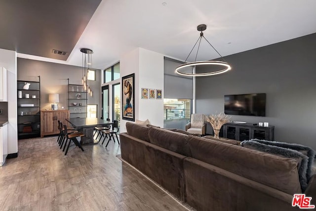 living room with a healthy amount of sunlight, hardwood / wood-style floors, and a chandelier