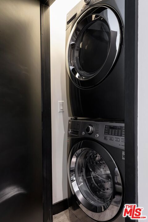 clothes washing area with stacked washer / dryer