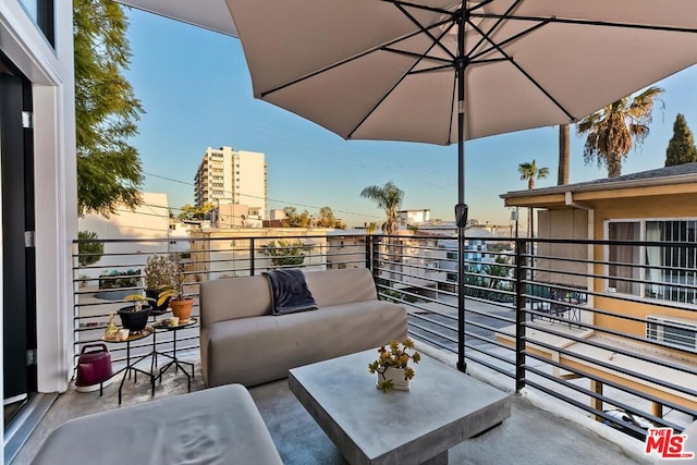 balcony at dusk featuring an outdoor living space