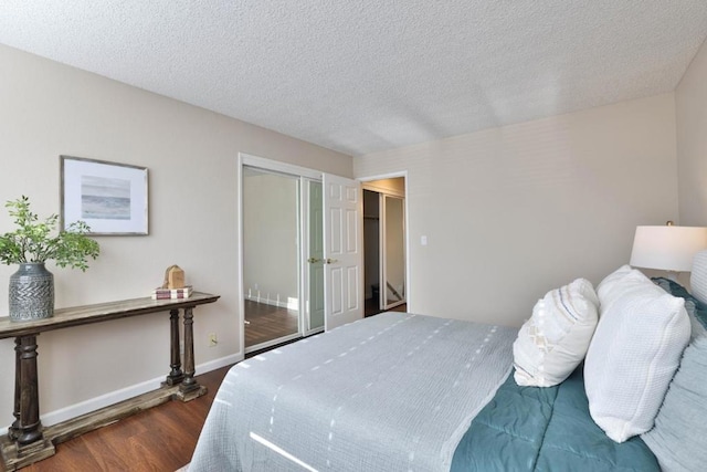 bedroom featuring dark hardwood / wood-style floors, a textured ceiling, and a closet