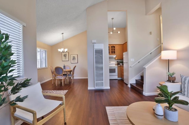 interior space featuring a notable chandelier, dark wood-type flooring, high vaulted ceiling, and a textured ceiling