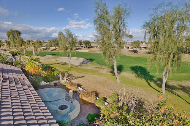 view of property's community featuring a lawn and an outdoor fire pit