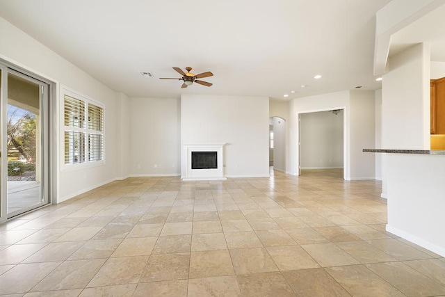 unfurnished living room featuring light tile patterned floors and ceiling fan