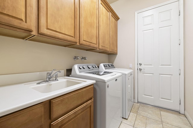 clothes washing area featuring cabinets, separate washer and dryer, sink, and light tile patterned floors