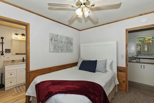 bedroom featuring ensuite bathroom, sink, crown molding, ceiling fan, and light hardwood / wood-style floors