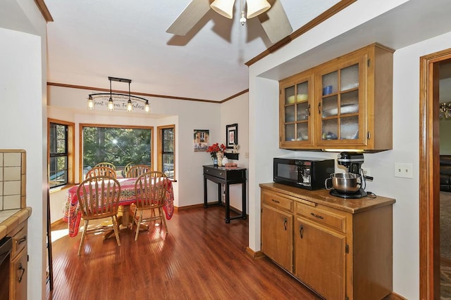 dining area with ornamental molding, dark hardwood / wood-style floors, and ceiling fan