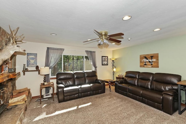 living room featuring a textured ceiling, ceiling fan, and carpet