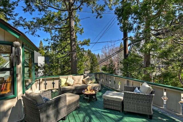 wooden deck with an outdoor living space with a fire pit