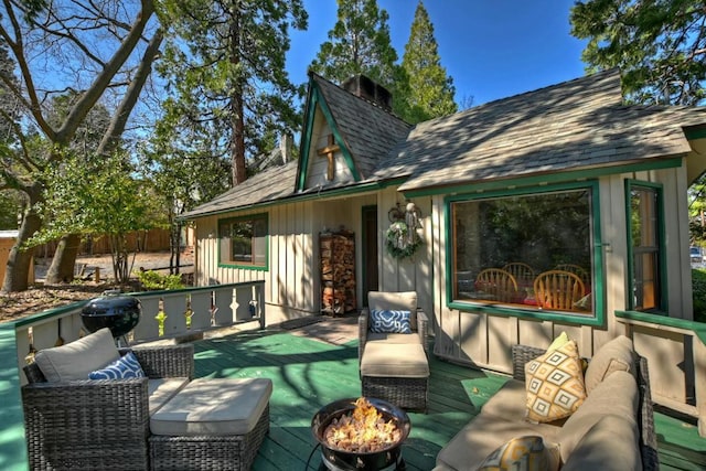 wooden terrace featuring an outdoor living space with a fire pit