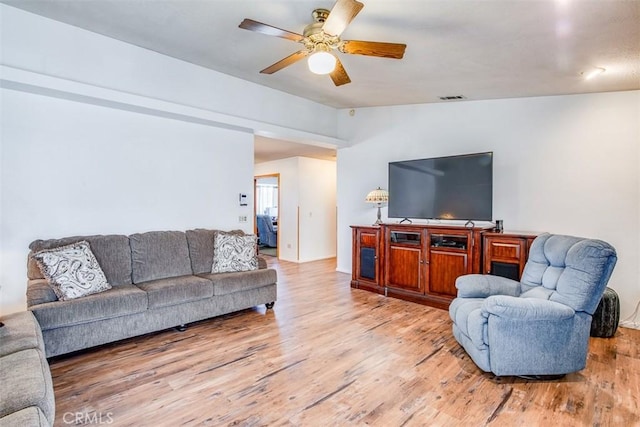 living room with lofted ceiling, ceiling fan, and light wood-type flooring