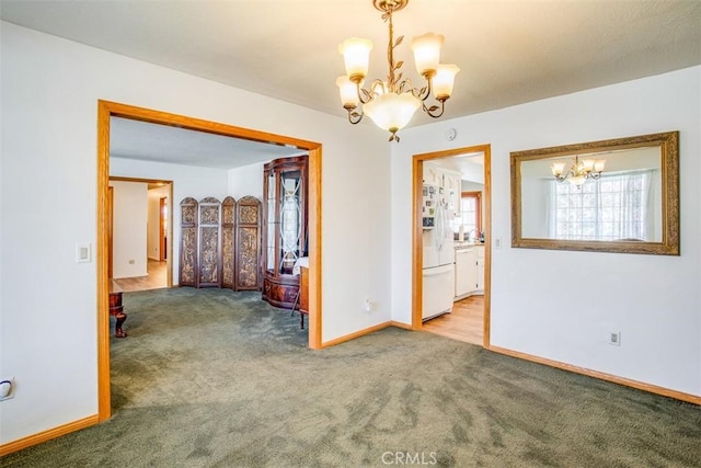 carpeted empty room with a notable chandelier