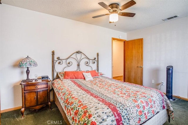 carpeted bedroom with ceiling fan and a textured ceiling