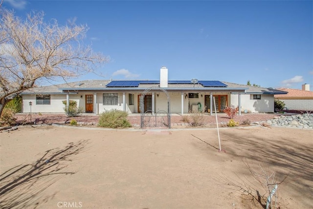 view of front of home featuring covered porch and solar panels