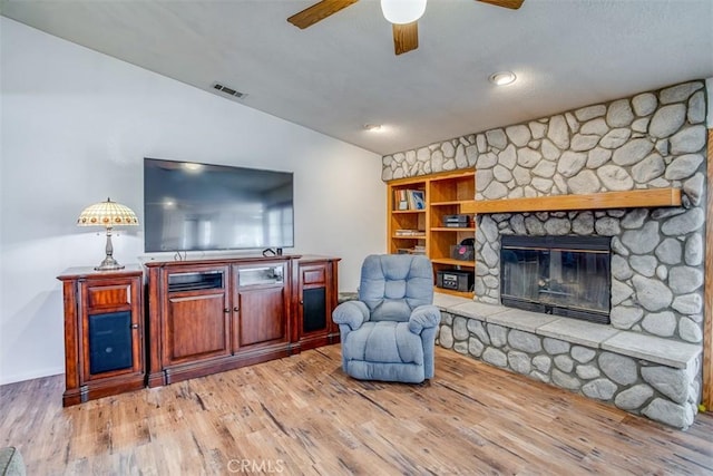 living room with vaulted ceiling, wood-type flooring, ceiling fan, and a fireplace