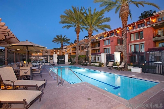 pool at dusk with a patio